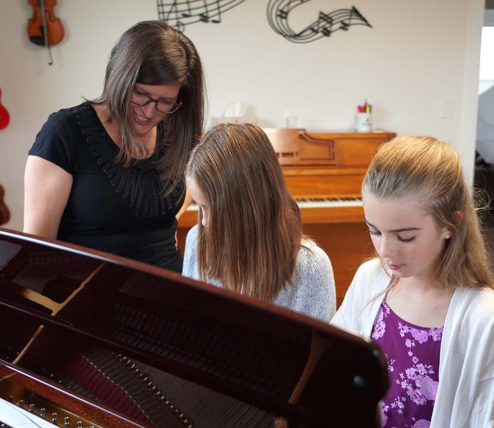 teacher and child playing piano